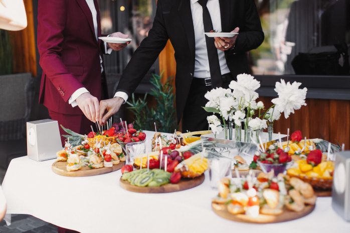 close-up-of-people-serving-themselves-with-fruits-in-buffet-of-restaurant